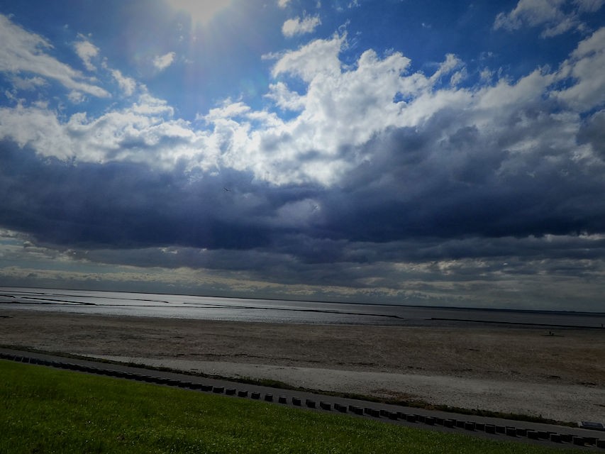 dunkle Wolken ziehen über Land und Meer